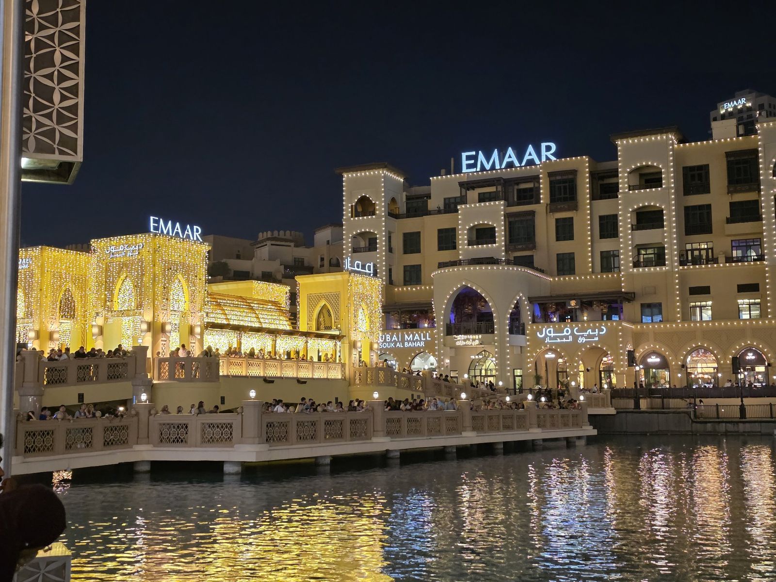 Souk Al Bahar lit up at night, seen from the waterfront bridge